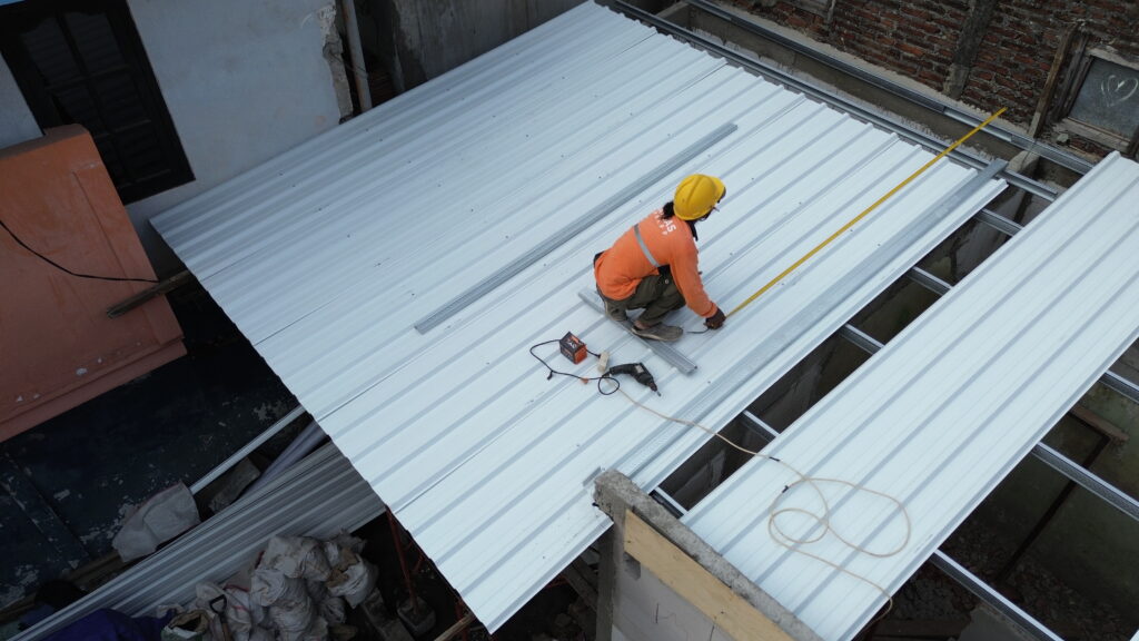 tukang sedang memasang atap UPVC