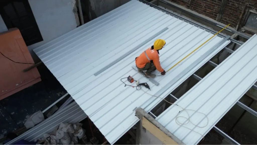 Orang yang sedang memasang atap UPVC